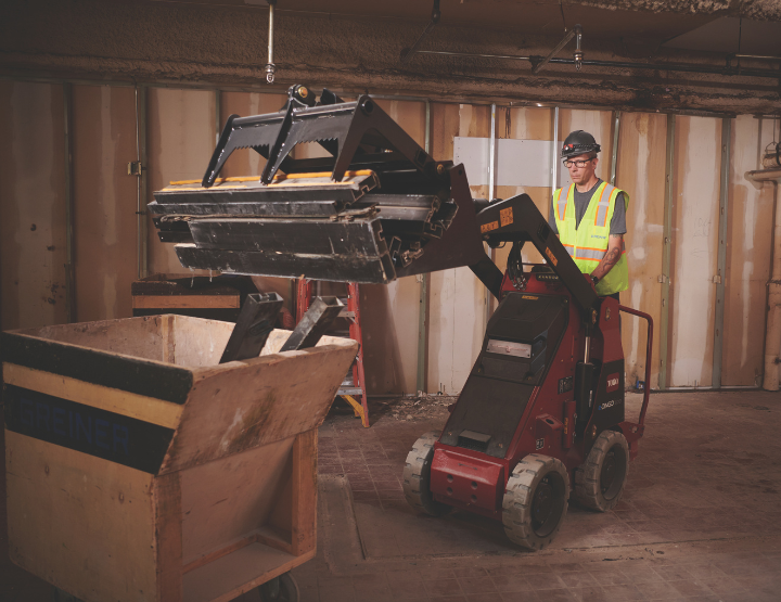 Man using Toro Dingo Grapple Bucket to lift material