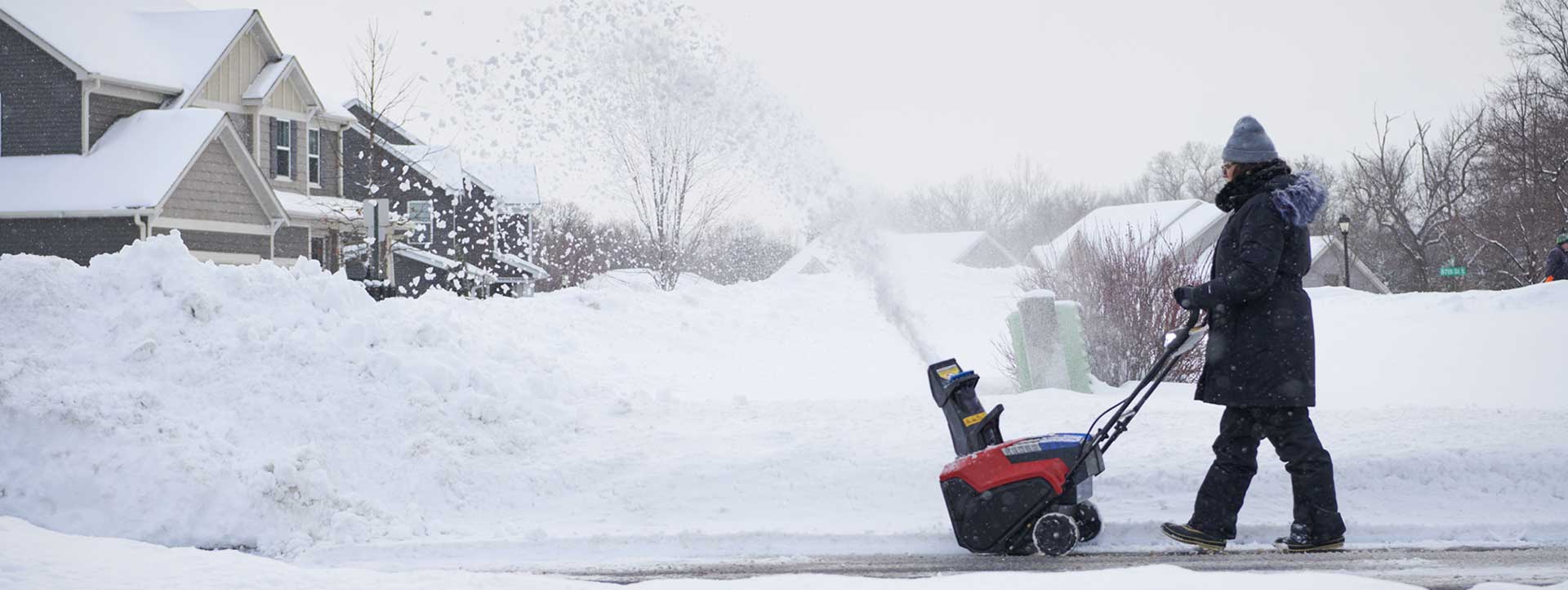 Woman clearing a driveway using a Toro Single Stage snow blower