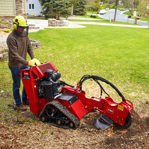 Stump Grinder STX 26 grinding a stump in a backyard